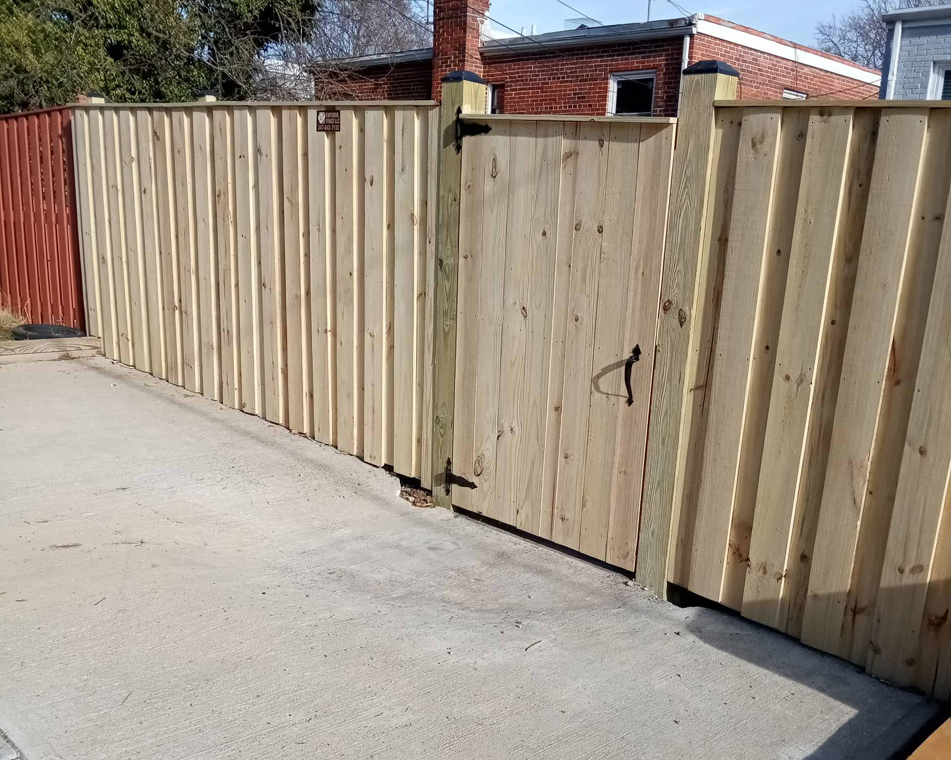 Wooden fence with gate built by Emperor Fence LLC