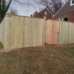 Wooden privacy fence with man door installed by Emperor Fence LLC